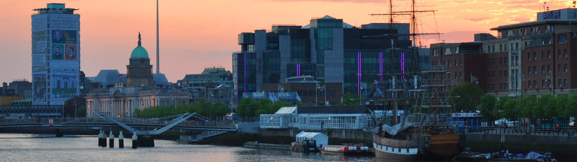 Sunset over Dublin City showing the river Liffey, the Jeanie Johnston along the quay, and the IFSC